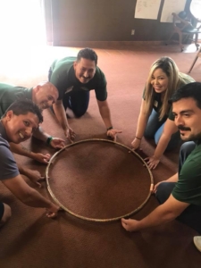 Picture of team-building exercise with hoop.